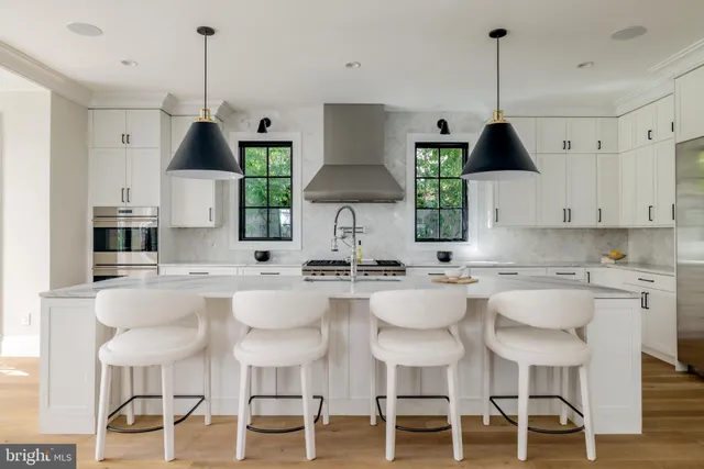 a kitchen with stainless steel appliances a sink stove and white cabinets