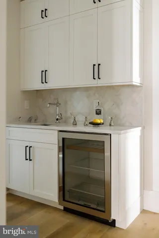 a utility room with stainless steel appliances white cabinets and a fireplace