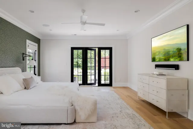 a bedroom with a large bed and a flat tv screen on dresser