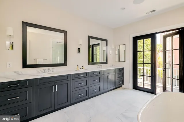 a spacious bathroom with double vanity and a large mirror