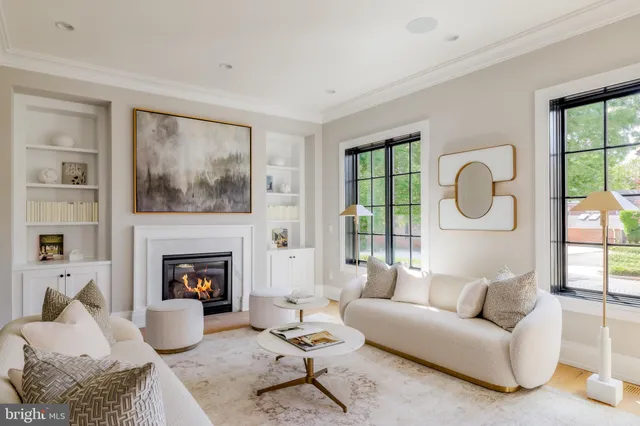 a living room with furniture a fireplace and a large window