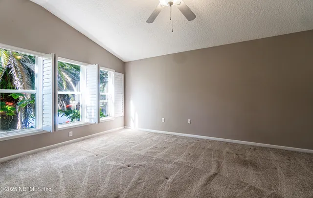 an empty room with closet and a ceiling fan