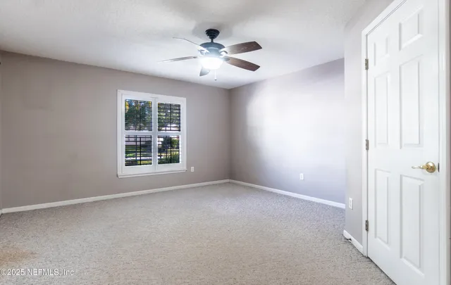 a view of a livingroom with a ceiling fan and window
