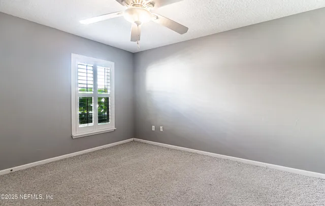 a view of a room with a ceiling fan and a window