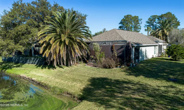an aerial view of residential houses with outdoor space and lake view