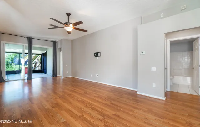 a view of a livingroom with wooden floor and a ceiling fan