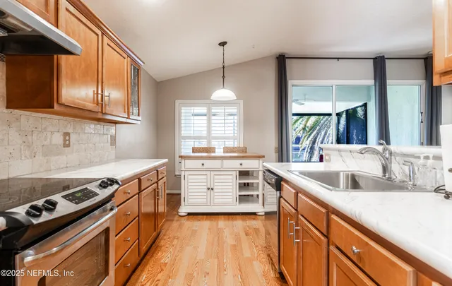 a kitchen with stainless steel appliances granite countertop a sink and dishwasher refrigerator stove