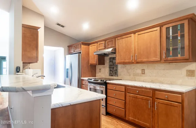 a kitchen with stainless steel appliances a sink and a refrigerator