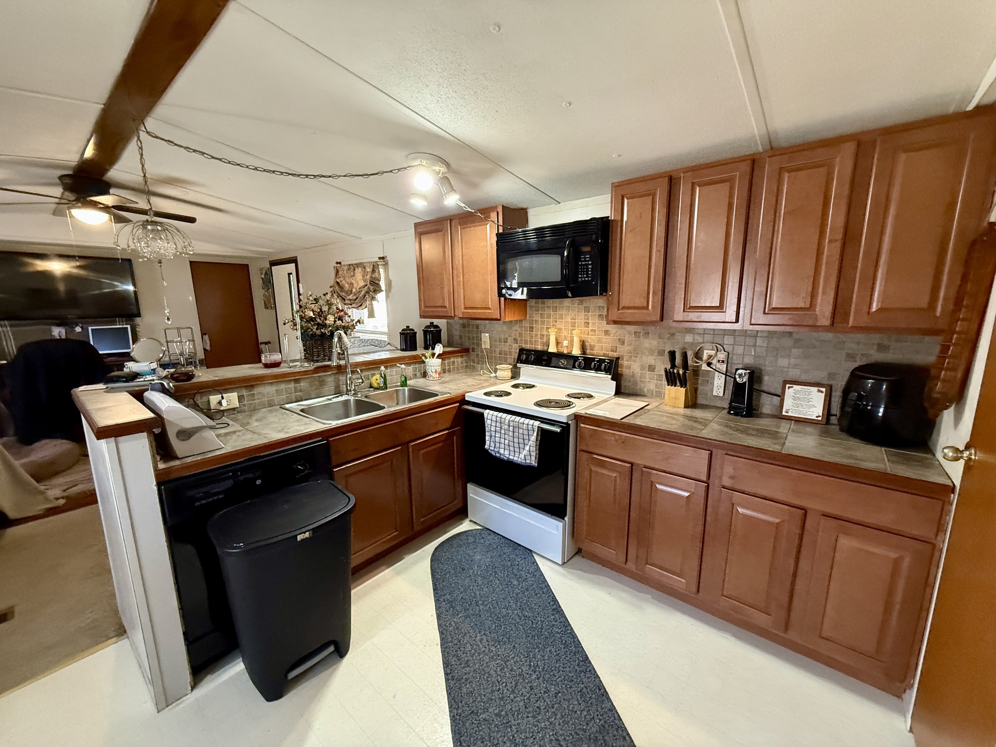 299 Sunset Drive Holladay, TN 38341 - Photo 2 of 27 a kitchen with stainless steel appliances granite countertop a sink dishwasher stove and microwave with wooden cabinets