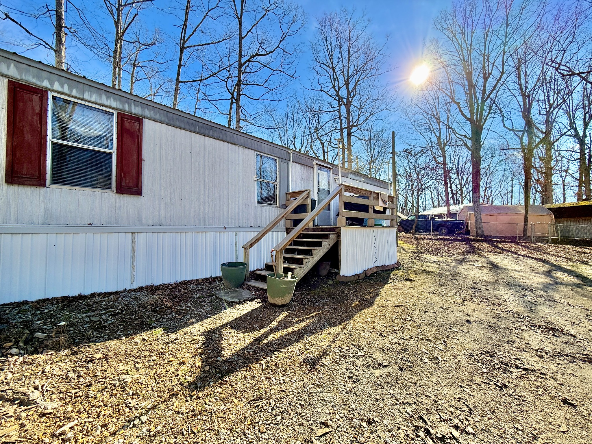 299 Sunset Drive Holladay, TN 38341 - Photo 4 of 27 a backyard of a house with wooden fence and trees