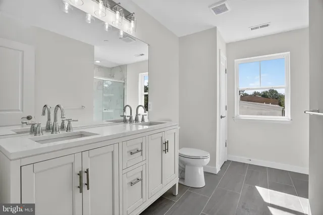 a spacious bathroom with a toilet sink and mirror