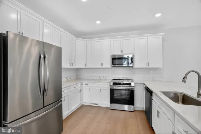a kitchen with white cabinets and stainless steel appliances