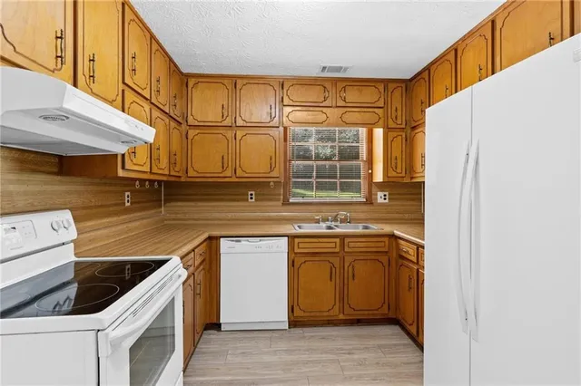 a kitchen with stainless steel appliances granite countertop a sink and a stove