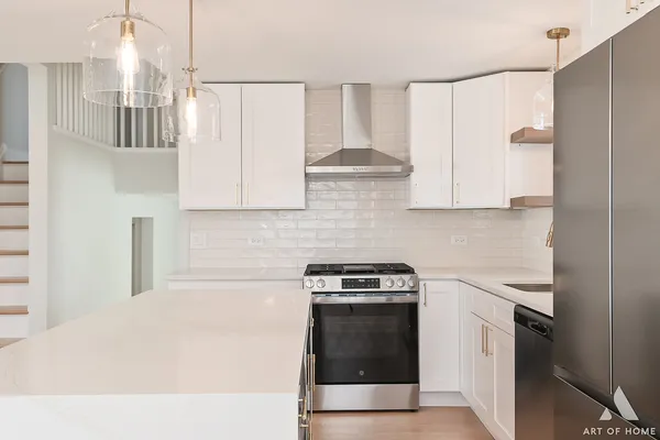 a kitchen with stainless steel appliances a stove a refrigerator sink and cabinets