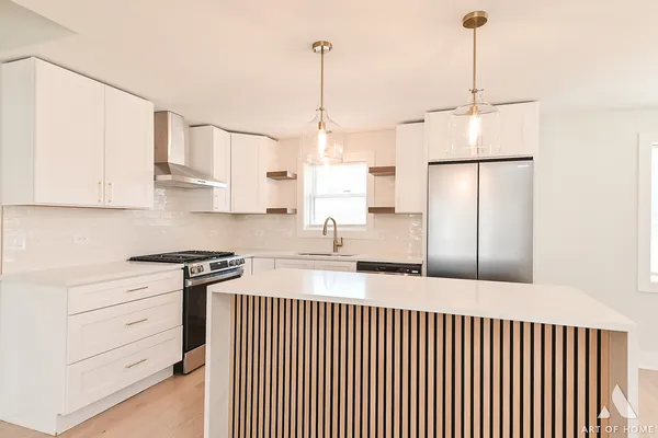 a kitchen with stainless steel appliances granite countertop a sink a stove and a wooden floors