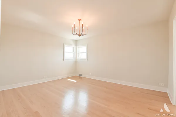 an empty room with wooden floor and window