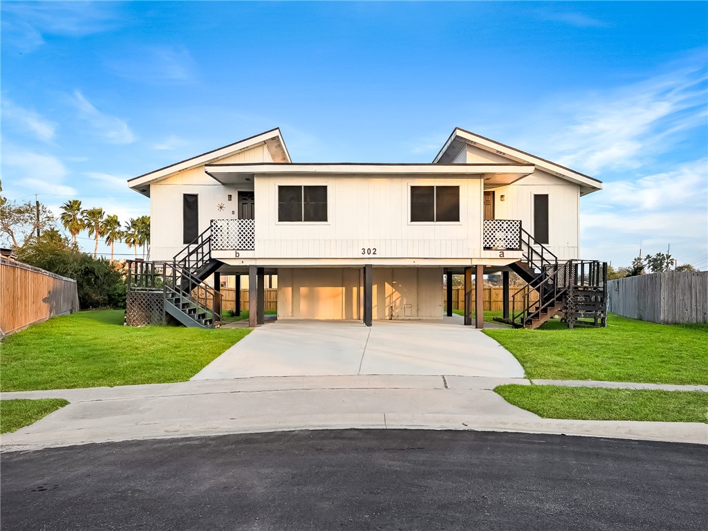 a white house that has tree in front of it