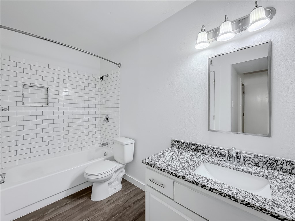 302 Easy Street, Unit B Corpus Christi, TX 78418 - Photo 14 of 27 a bathroom with a granite countertop toilet sink and mirror