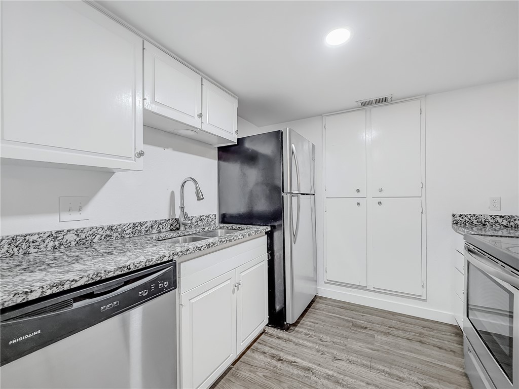 302 Easy Street, Unit B Corpus Christi, TX 78418 - Photo 9 of 27 a kitchen with stainless steel appliances granite countertop a sink stove and refrigerator