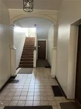 a view of a hallway with wooden floor and stairs