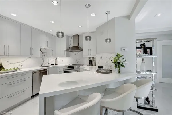 a kitchen with a sink a stove cabinets and chairs