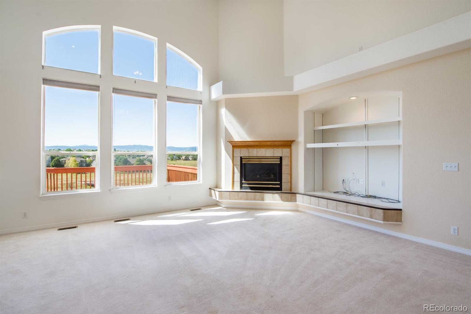 466 West Angus Way Highlands Ranch, CO 80129 - Photo 8 of 29 an empty room with windows and fireplace