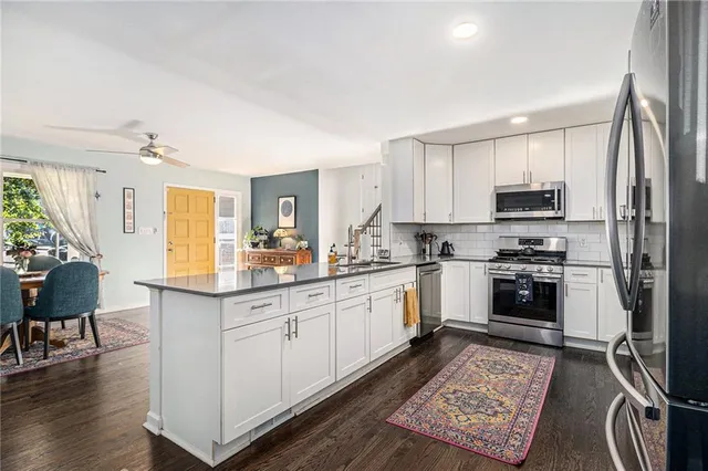 a kitchen with granite countertop a stove a sink and a refrigerator