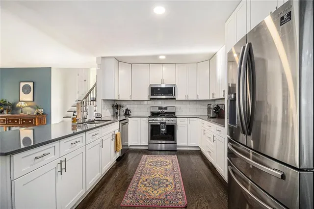 a kitchen with white cabinets and stainless steel appliances