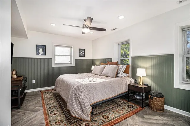 a bedroom with a bed wooden floor and window