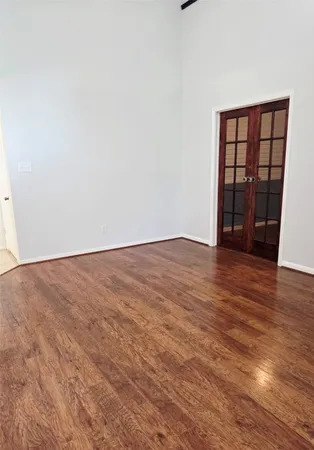 an empty room with wooden floor and a window