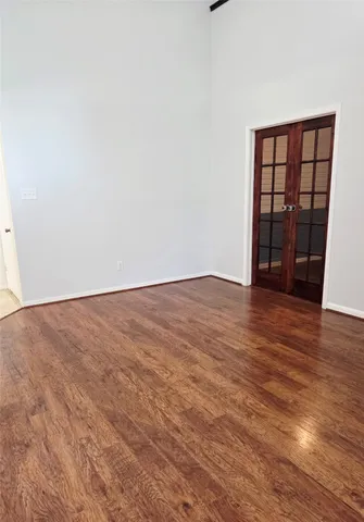 an empty room with wooden floor and a window