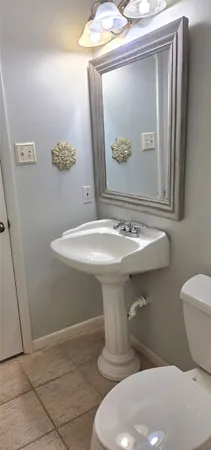 a bathroom with a sink toilet and mirror