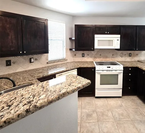 a kitchen with stainless steel appliances granite countertop a sink stove and microwave