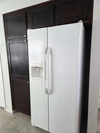 a white refrigerator freezer and a wooden floor