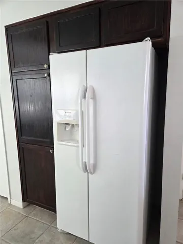 a white refrigerator freezer and a wooden floor