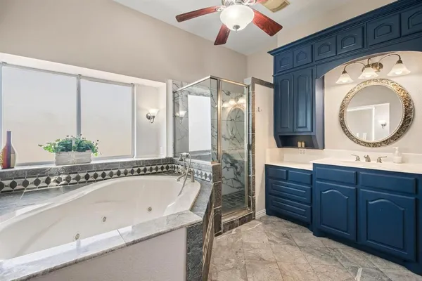 a bathroom with a tub sink and mirror