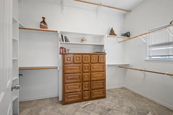 a view of walk in closet with clothes