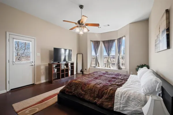 a bedroom with a large bed and a flat tv screen