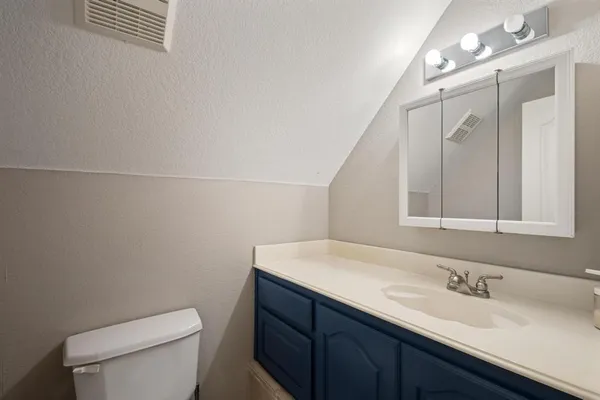 a bathroom with a sink a toilet and mirror