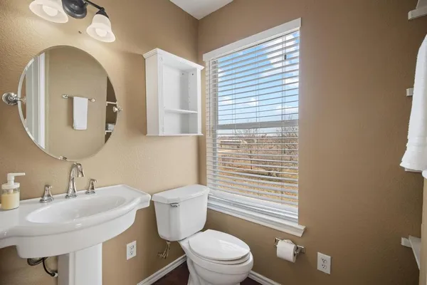 a bathroom with a toilet a sink and mirror