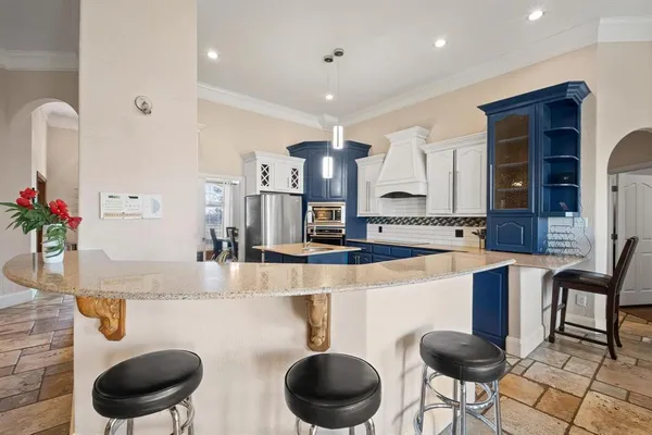 a kitchen with stainless steel appliances granite countertop a sink a stove and a wooden cabinets