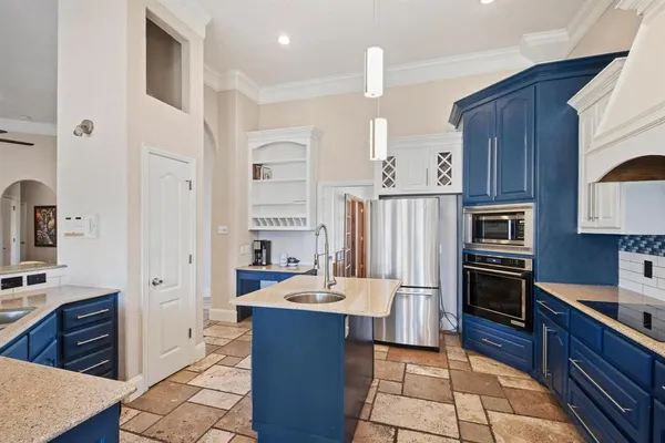 a kitchen with stainless steel appliances granite countertop a refrigerator stove and sink