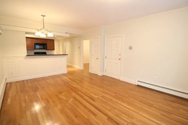 a view of a kitchen with wooden floor and a ceiling fan