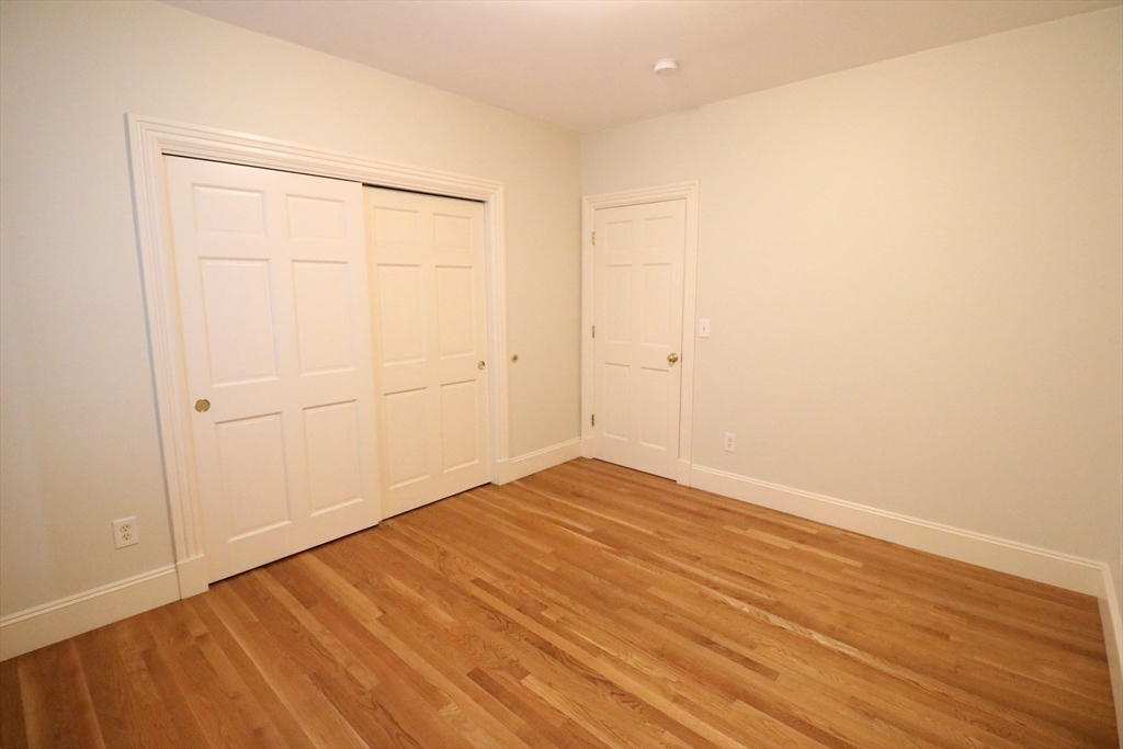 8 Caldwell Avenue, Unit 2 Somerville, MA 02143 - Photo 8 of 16 a view of an empty room with wooden floor