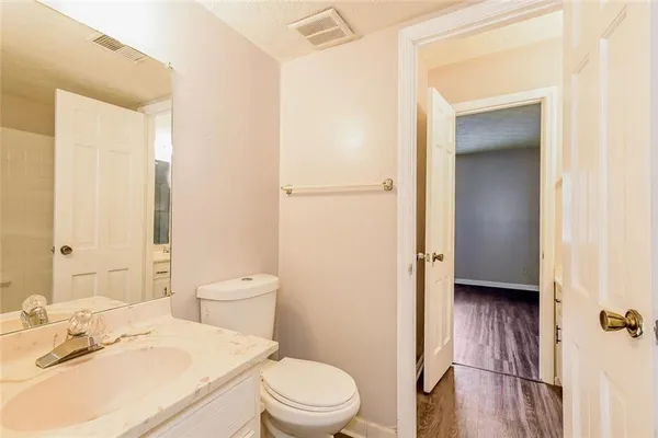 a bathroom with a granite countertop toilet sink and a mirror