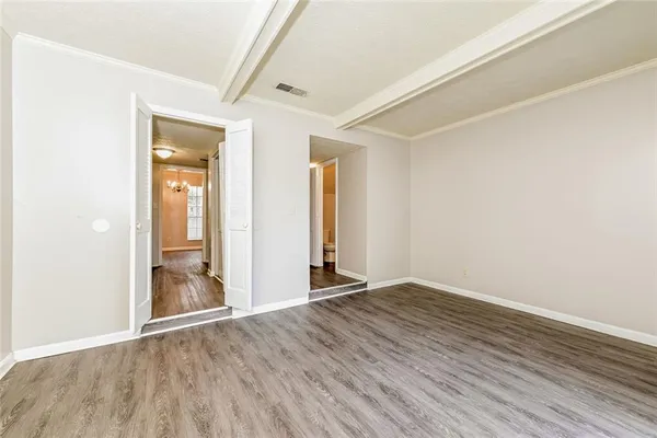 an empty room with wooden floor and mirror