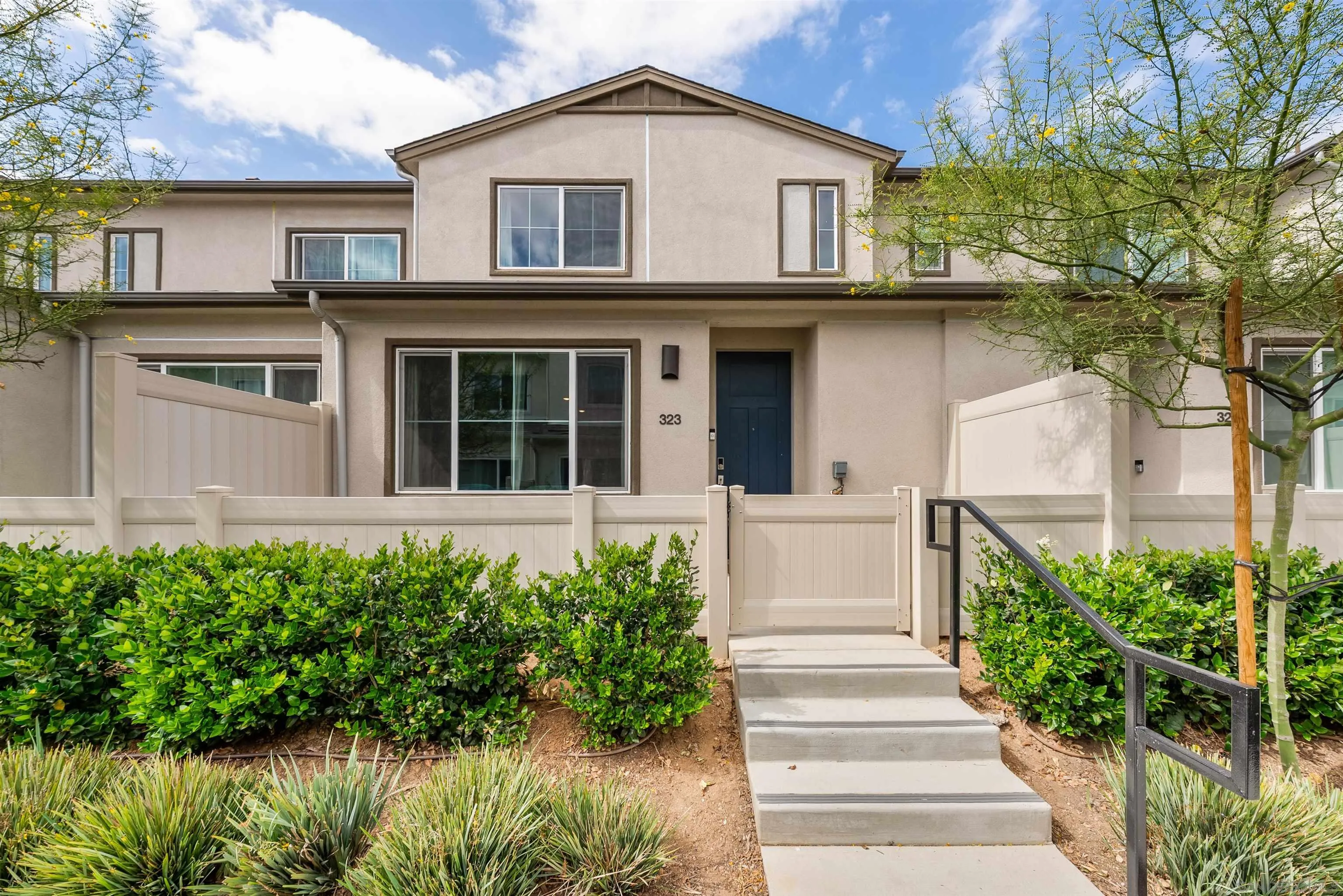 323 Satsuma Trail Fallbrook, CA 92028 - Photo 2 of 28 a view of a white house with large windows and a small yard