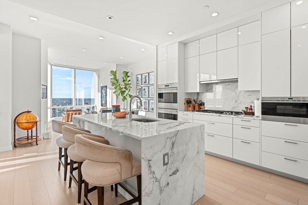 1 Franklin Street, Unit 5002 Boston, MA 02110 - Photo 12 of 40 a kitchen with stainless steel appliances granite countertop a table and chairs
