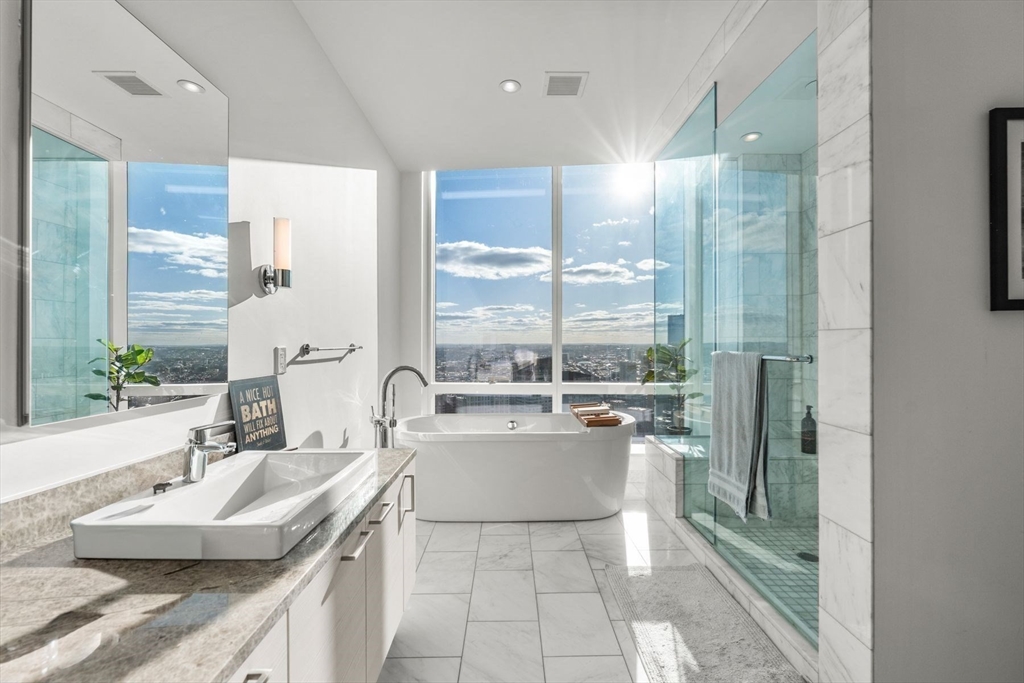 1 Franklin Street, Unit 5002 Boston, MA 02110 - Photo 20 of 40 a large bathroom with a granite countertop sink a large mirror and a bathtub