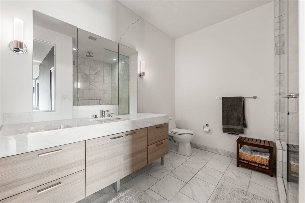 1 Franklin Street, Unit 5002 Boston, MA 02110 - Photo 21 of 40 a bathroom with a toilet a sink and mirror